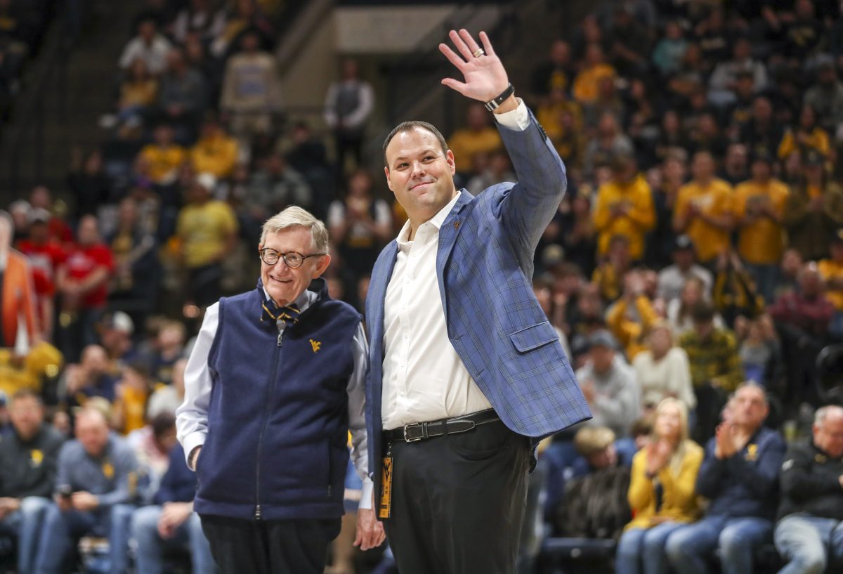 Dec 18, 2022; Morgantown, West Virginia, USA; West Virginia University President Gordon Gee welcomes new West Virginia Mountaineers Athletic Director Wren Baker during the first half against the Buffalo Bulls at WVU Coliseum. Mandatory Credit: Ben Queen-USA TODAY Sports