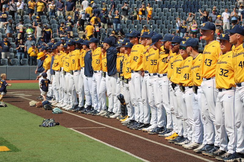 West Virginia Baseball team locks arms before the first pitch.