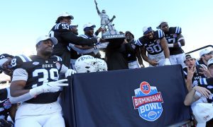 Dec 23, 2023; Birmingham, AL, USA; Duke Blue Devils players and interim head coach Trooper Taylor celebrate with the Birmingham Bowl trophy after defeating the Troy Trojans at Protective Stadium. Mandatory Credit: Petre Thomas-USA TODAY Sports