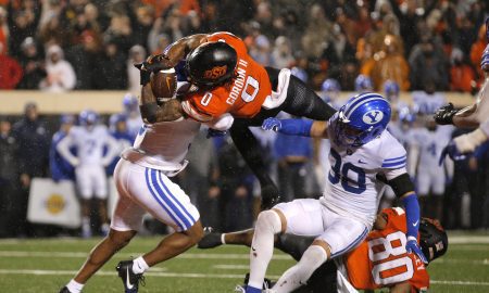 Nov 25, 2023; Stillwater, Oklahoma, USA; Oklahoma State's Ollie Gordon II (0) scores a touchdown in the second overtime against BYU's Eddie Heckard (5) and Crew Wakley (38) at Boone Pickens Stadium. Mandatory Credit: Sarah Phipps-USA TODAY Sports