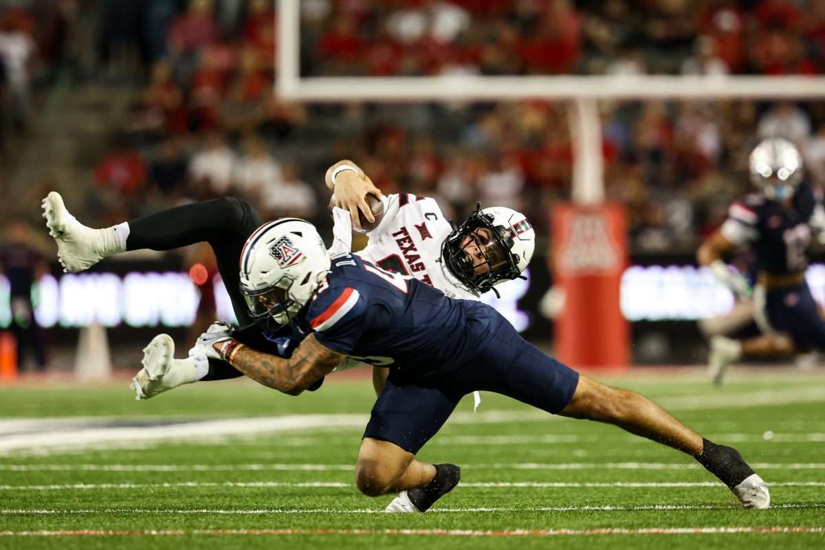 Oct 5, 2024; Tucson, Arizona, USA; Arizona Wildcats defensive back Dalton Johnson (43) tackles Texas Tech Red Raiders quarterback Behren Morton (2) during third quarter at Arizona Stadium. Mandatory Credit: Aryanna Frank-Imagn Images
