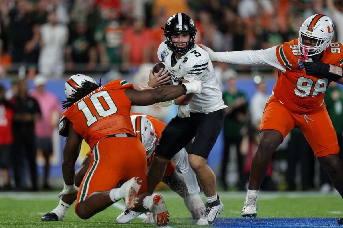 Dec 28, 2024; Orlando, FL, USA; Iowa State Cyclones quarterback Rocco Becht (3) is pressured by Miami Hurricanes defensive lineman Simeon Barrow Jr. (10) in the fourth quarter during the Pop Tarts bowl at Camping World Stadium. Mandatory Credit: Nathan Ray Seebeck-Imagn Images