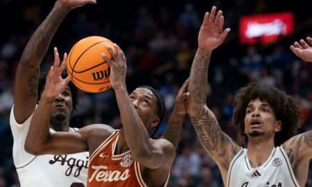 Texas Longhorns guard Tramon Mark (12) grabs a rebound in front of Texas A&M forward Solomon Washington (9) and forward Andersson Garcia (11) during their second round game of the SEC Men's Basketball Tournament at Bridgestone Arena in Nashville, Tenn., Thursday, March 13, 2025.