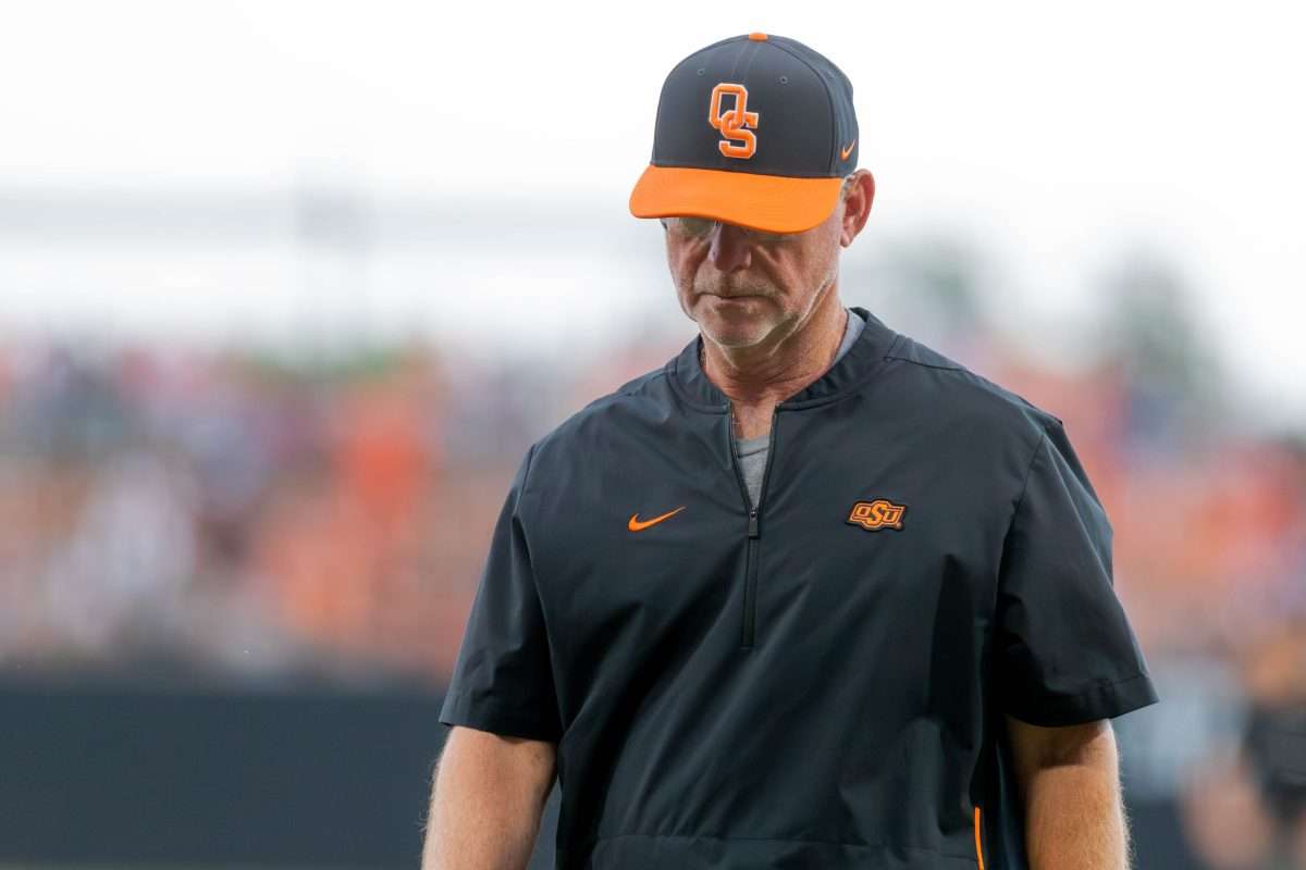 Oklahoma State assistant Coach Rob Walton walks off the field after talking to Oklahoma State utility Nolan McLean (13) during a game in the NCAA Stillwater Regional between the Oklahoma State Cowboys (OSU) and the Oral Roberts Golden Eagles at O'Brate Stadium in Stillwater, Okla., on Friday, June 2, 2023.