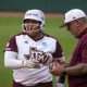 Texas A&M assistant coach Russ Heffley talks to infielder Mya Perez 24) on first base during the NCAA D1 Softball Tournament Regional against Saint Francis University at Davis Diamond at Texas A&M University on Friday, May 16, 2025 in College Station, Texas.
