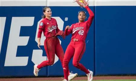 Jun 2, 2025; Oklahoma City, OK, USA; Texas Tech Red Raiders outfielder Mihyia Davis (42) makes a catch for an out as outfielder Demi Elder (2) backs her up in the third inning against the Oklahoma Sooners during the NCAA Softball Women's College World Series semifinal game at Devon Park. Mandatory Credit: Brett Rojo-Imagn Images