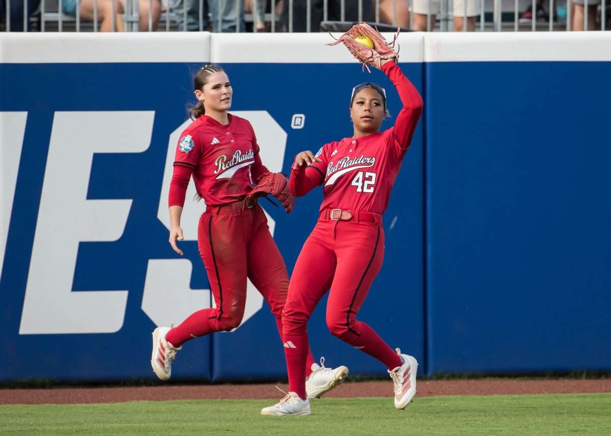 Jun 2, 2025; Oklahoma City, OK, USA; Texas Tech Red Raiders outfielder Mihyia Davis (42) makes a catch for an out as outfielder Demi Elder (2) backs her up in the third inning against the Oklahoma Sooners during the NCAA Softball Women's College World Series semifinal game at Devon Park. Mandatory Credit: Brett Rojo-Imagn Images