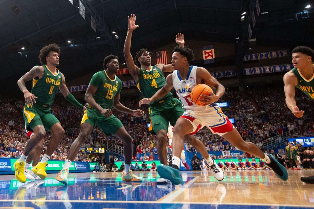 Kansas freshman guard Elmarko Jackson (13) drives the ball against Baylor players in the second half of the game Saturday, February 10, 2024 inside Allen Fieldhouse.
