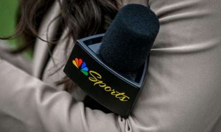 A Peacock sideline reporter holds a microphone with the NBC Peacock logo during Michigan State's football game against Washington on Saturday, Sept. 16, 2023 at Spartan Stadium in East Lansing, Michigan.
