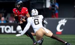 Cincinnati Bearcats quarterback Brendan Sorsby (2) runs as UCF Knights edge Isaiah Nixon (6) attempts to tackle him in the second quarter of the NCAA football game between the Cincinnati Bearcats and UCF Knights at Nippert Stadium in Cincinnati on Oct. 11, 2025.