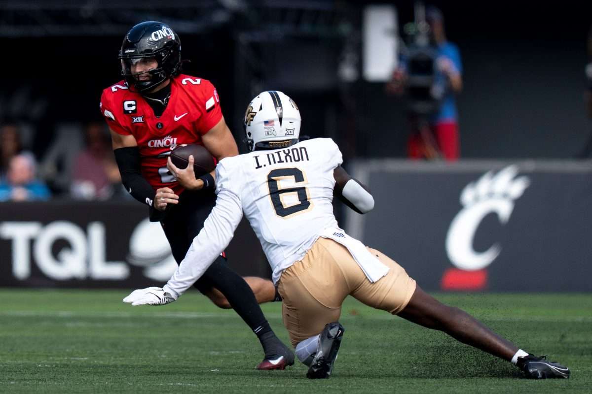 Cincinnati Bearcats quarterback Brendan Sorsby (2) runs as UCF Knights edge Isaiah Nixon (6) attempts to tackle him in the second quarter of the NCAA football game between the Cincinnati Bearcats and UCF Knights at Nippert Stadium in Cincinnati on Oct. 11, 2025.